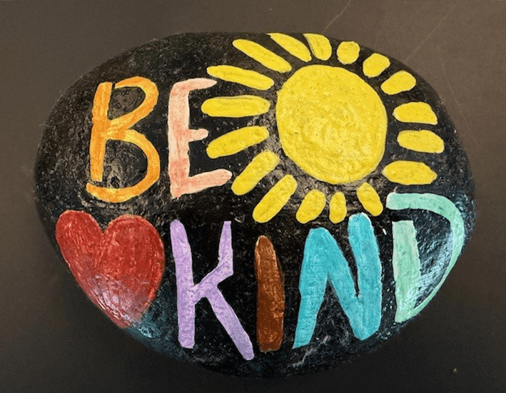 Hand painted stone with sun, heart and Be Kind text
